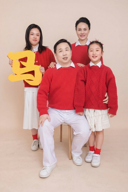 这是一张一家四口的照片，请将妈妈脸上的皱纹和褶子去掉，将妈妈的发型改成盘头发，将爸爸的皮肤调白一些，将爸爸的肚子变小一点预览效果