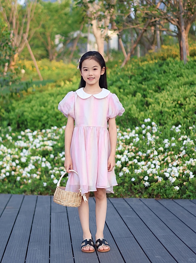 将图中人物脚上的白色凉鞋替换为图2的黑棕拼色H型设计凉拖，适配人物站姿脚型，保证姿势、画面风格、比例完全不变。参考其余鞋子的细节，突出鞋子精致皮革工艺，整体提升画面质感，8K超高清，边缘干净无畸变，清晰对焦，商业摄影质感。