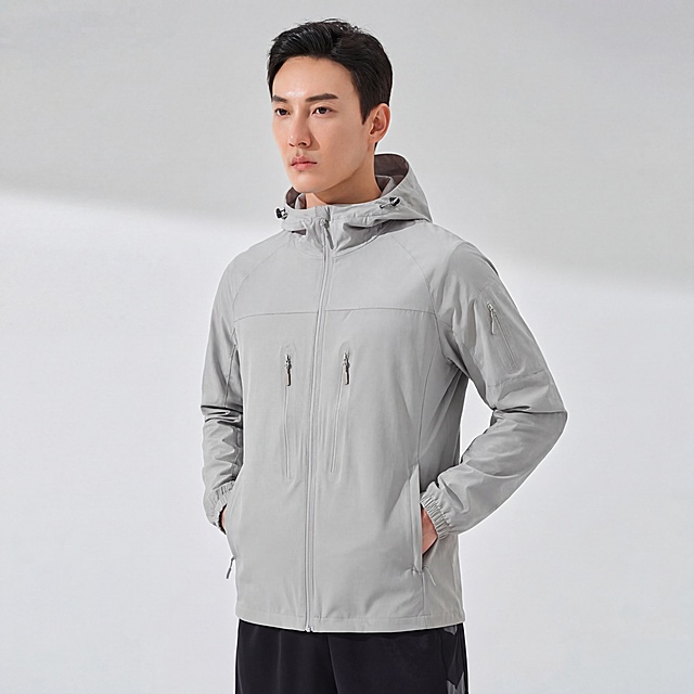 将提供的浅灰色夹克，完全贴合到图3中模特的身形上，完全保留衣服原有的版型、颜色、细节，包括拉链、纽扣、口袋的位置都保持不变，无任何变形和颜色偏差。场景为灰色地面搭配白色背景，商业高调摄影，柔和漫射光，光线自然均匀，保留真实光影和阴影。写实风格，8k分辨率，高细节，对焦清晰，画面干净简洁。要求衣服完全贴合，无违和感，物理融合自然，保持模特原有双手插兜的姿态。