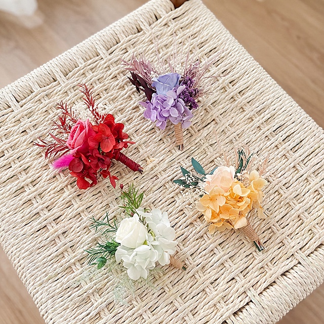 基于原图中的四支干花小花束产品，保持每支花束的主体物理结构、色彩和组成不变，放置在参考图的藤编家具场景中，参考图的浅米色编织网格台面布局，四支花束分散摆放，保持50%的构图相似度。商业高调摄影，柔和漫射光，通透氛围，北欧自然风，浅色调，真实摄影质感，前中后景层次，光影自然，画面真实精致，4K超清分辨率。禁止改变花束本身结构与色彩。