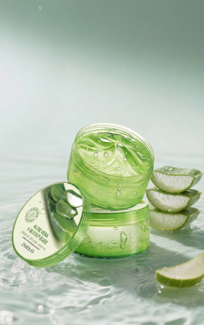 基于输入图，仅保留前景的芦荟凝胶产品（含盖子与切片芦荟），彻底删除背景中所有芦荟叶片；保持水面、水珠飞溅效果与产品原有光影（左上光源）、投影及通透质感；背景改为纯净渐变青绿色虚化背景，突出主体，符合国预览效果