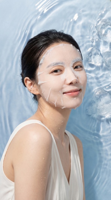 参考图中清透水润的浅蓝色水波纹与冰块的清爽氛围感，生成一位面容姣好的韩国女性模特的半身像，她身材纤瘦，穿着轻盈的白色连衣裙，脸上敷着水润的白色薄款面膜，神情愉悦舒适，使用佳能相机拍摄，对焦清晰真实，符预览效果