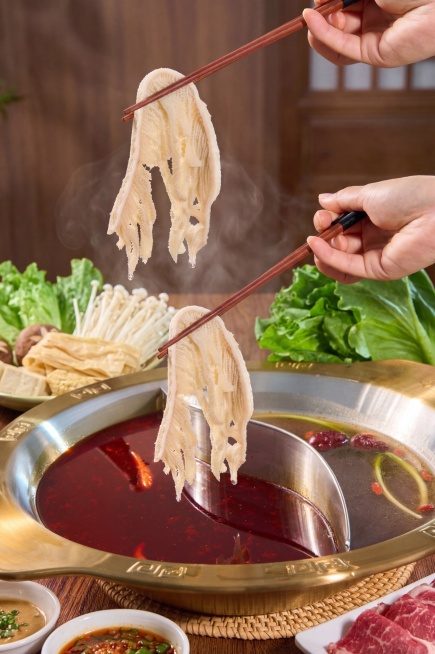 将两张图片中的新鲜速冻千层毛肚融合为一张商品使用场景图，100%保留两张图片中千层毛肚原本的细节、纹理、外观、形态、颜色、透视，不对毛肚做任何修改、变形、重绘。将毛肚自然融入火锅就餐场景，保持毛肚主体预览效果