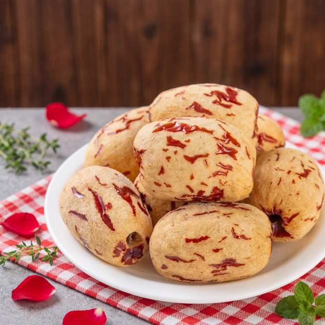 虎皮枣，去掉外皮后露出浅米黄色果肉带红褐色纹理，堆放在白色瓷盘上，保持产品物理结构绝对不变，严禁扭曲变形。主体放在浅灰色水泥台面上，深棕色原木背景，户外野餐风，格纹餐布衬托，拉开景深。午后暖调窗光，柔预览效果