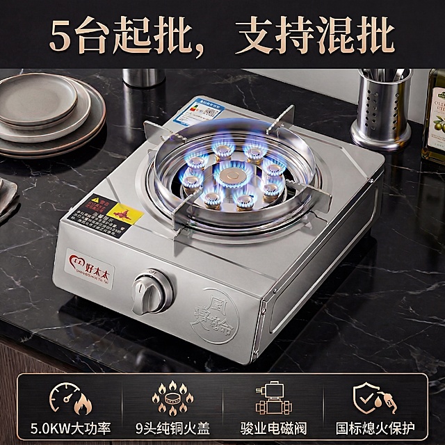家用液化气单灶，不锈钢机身，保留原图产品所有细节、品牌贴标和警告标签，九头纯铜火盖正燃烧蓝色火焰，45°侧俯新角度，背景为黑色大理石台面，搭配浅灰色陶瓷盘、银色金属筷筒、橄榄油瓶等厨房摆件，与参考图同色系但位置错落，顶部用金色复古宋体写"5台起批，支持混批"，底部深色功能栏配白色图标+文字："5.0KW大功率"、"9头纯铜火盖"、"骏业电磁阀"、"国标熄火保护"，暖调打光突出金属质感，无水印，高清商用图，背景是黑色大理石台面，配色保持不锈钢银+火焰蓝+深黑+金色，标题金色复古宋体，正文白色无衬线体