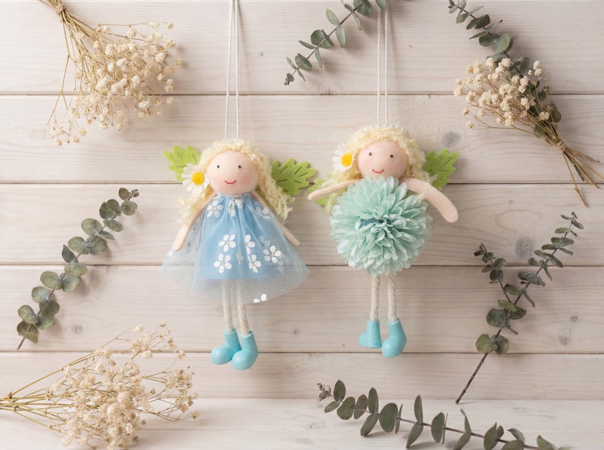 保持两个手工布艺玩偶挂件的原有造型、颜色和材质不变，将它们挂在ins简约风格的原木墙面场景中展示，整体风格干净清新，符合ins美学，商业摄影柔光，浅景深，背景柔和虚化，添加少量干花装饰点缀，画面通透自预览效果