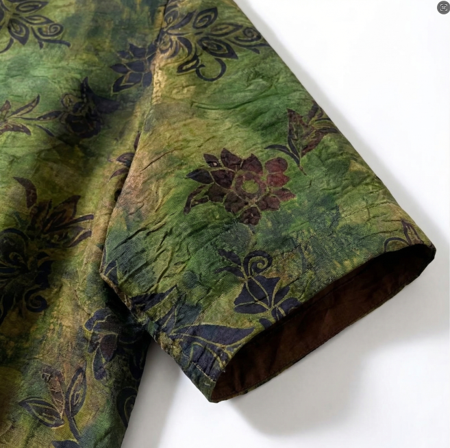 生成这件香云纱上衣的袖子局部特写图片，重点突出袖子部分的面料纹理和花色细节，保持原有的绿底植物花卉纹样和棕色内衬质感预览效果