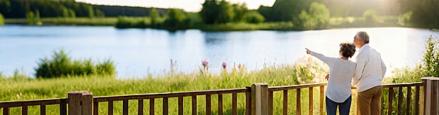 给湖面增加一些蓝色调，给前景和岸边的绿植适当增加更多绿色，让整体色调更清新自然，保留原图中两位老人的姿势、构图和整体光影氛围不变