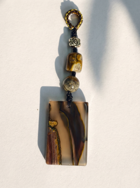 自然光下平放拍摄，完整展示无事牌全貌，突出崖棕鎏金整体色调与版型质感，保留原有纹理和颜色特征，光影自然柔和预览效果