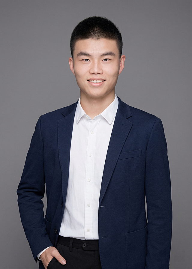 参考图中人物脸型发型年龄生成资深教师形象照，藏青色休闲西装白衬衫，自然站姿左手插兜，中性灰纯色背景，专业摄影，写实风格