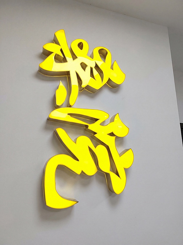 抠出发光黄色字体主体，保持主体内容和发光效果不变，将主体安装在干净的墙面上，高清实拍质感，细节清晰，光影自然