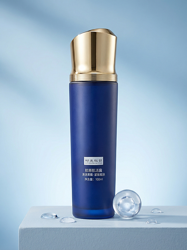 [主图 1] 时光秘钥胶原肌活露品牌首图（精准复刻实物）
[氛围风格] 高级静物摄影，纯净柔光，通透水润质感，强调产品真实材质与细节。
[画面元素] 商业摄影级写实质感，光线柔和均匀，产品清晰真实无失真100%还原参考图。深蓝色磨砂瓶身居中放置于浅灰蓝石膏静物台上; 瓶帽为金色金属弧顶结构，顶部有明显凸起曲面，中部环绕多层细密螺纹装饰带；瓶身正面白色标签框内含‘时光秘钥 SHIGUANGMIYUE’‘胶原肌活露’‘滴滴菁露·紧致靓肤’‘净含量：100ml’等文字，全部保留原样、清晰可辨；周围点缀3-4颗透明水珠与1个半透明胶原蛋白分子球（不遮挡产品），背景为柔焦浅蓝渐变，无边框、无额外文字。
[配色色系] 主色：深蓝磨砂瓶身、香槟金瓶帽；辅色：浅灰蓝背景、透明水珠/分子球。
[视角构图] 正前方平视微仰角，景深适中，突出瓶身立体感与瓶帽工艺细节。
[文字版式] 无新增文字！仅保留产品自带印刷文字，确保其清晰、未被遮挡、未变形。
[比例分辨率] 3:4，4K，JPG格式。
[负向提示词] 变形，水印，AI生成文字，额外标题，模糊，镜面高光过强，瓶帽结构错误（如平顶/单圈/无弧顶），标签错位或缺失。