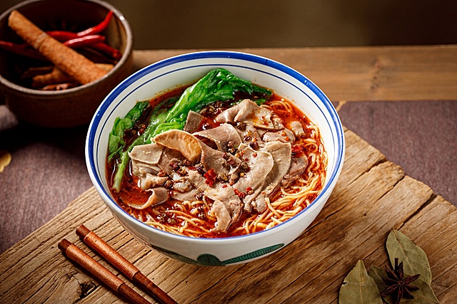 仅改变汤底，将原图中的清汤汤底替换为红亮香辣的汤底，保持其他元素不变