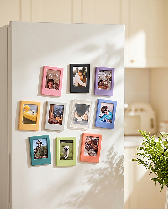 十个马卡龙彩色磁吸小相框冰箱贴，保持原图每个冰箱贴的颜色、图案和物理结构绝对不变，严禁扭曲变形。所有冰箱贴作为整体吸附在哑光白色冰箱门上，有清晰接触阴影，各冰箱贴位置排布自然，严禁结构穿模。温馨奶油风家居场景，浅奶白色空间背景，拉开景深。柔和暖调漫射柔光，窗外照进明亮窗光，画面明亮干净，低对比度，阴影极淡。树叶斑驳光影点缀，旁边点缀一小束鲜切绿植，营造治愈氛围感。商业静物摄影，4K分辨率，干净通透，种草氛围。严格锁定宽高比为4:5。

负向词：接口错位,结构变形,穿模,重叠,生锈,老旧破损,悬空,比例失调,水印,文字,昏暗,杂乱,西方面孔,金发,深眼窝,雀斑,死黑阴影,硬光,高对比度,多余同款冰箱贴