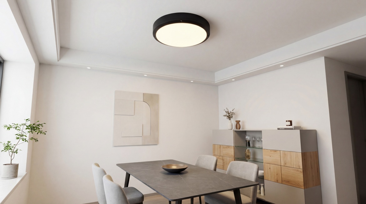 将图中这款圆形超薄LED吸顶灯调整为仰视角度，安装在现代简约风餐厅天花板正中央。主体为黑色金属边框+高透柔光白色灯面，发出均匀柔和的暖白光；空间搭配长方形岩板餐桌，4把浅灰色软包餐椅，餐边柜做浅灰+原预览效果
