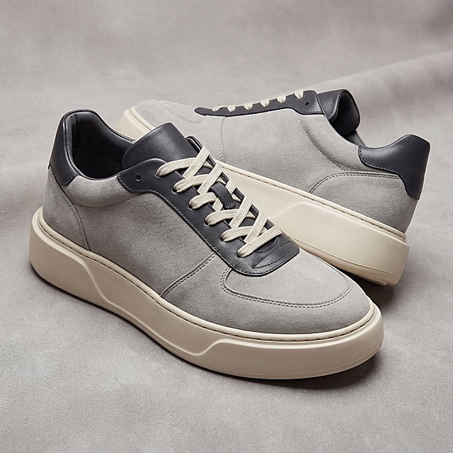 生成一双厚底鞋，使用参考图中的猪八革浅灰色细腻绒面皮革纹路材质，鞋子整体搭配另外一种不同材质，不要全身都是一种颜色，厚底鞋放置在同款猪八革皮革表面上，高端产品摄影，质感清晰