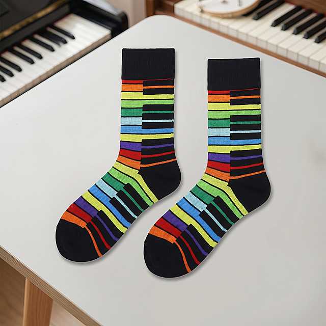 一双黑色带彩虹钢琴键图案男士袜子，保持原产品的图案和物理结构绝对不变，严禁扭曲变形。两只袜子分开平铺摆放，留有间距，主体占画面70%，自然放置在桌面上，有柔和接触阴影。放置在浅灰磨砂桌面，背景融入钢琴琴键音乐元素，不是黑色背景，室内风格，拉开景深。国内电商种草风，柔和漫射光影，低对比度，阴影极淡，画面明亮干净。居中构图，微俯视视角。点缀细微木质纹理质感，打破单调。商业高端电商摄影，4K分辨率，极高材质细节。严格锁定宽高比为1:1。