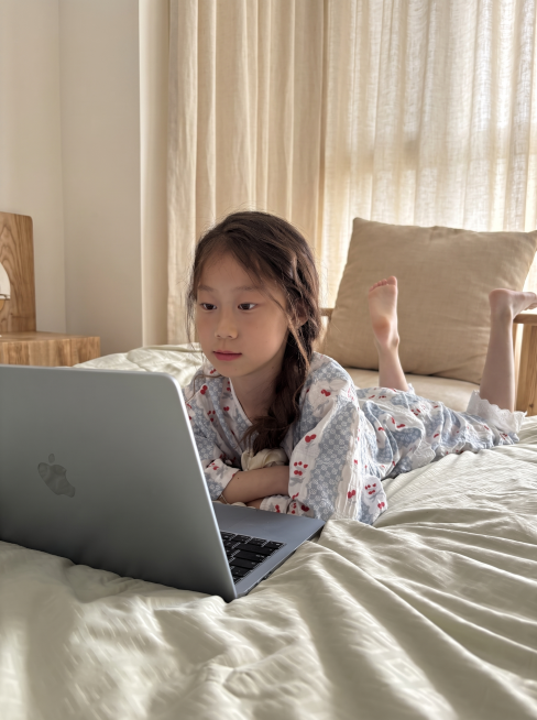 参考前两张参考图的温馨家居风格，将原图https://6.jpg的背景换成干净柔和的居家场景，保留小女孩模特和身上的蓝红樱桃家居服，整体自然，适合拼多多详情页预览效果