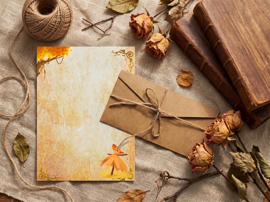 超写实静物摄影，俯拍45°视角，将参考图中的复古信封套装平铺在亚麻纱布上，左侧放展开的信纸，右侧放着信封，信封和信纸叠放着，整体自然；画面右侧点缀干枯玫瑰花和复古书本，左上角放置一团天然黄麻绳球，背景预览效果