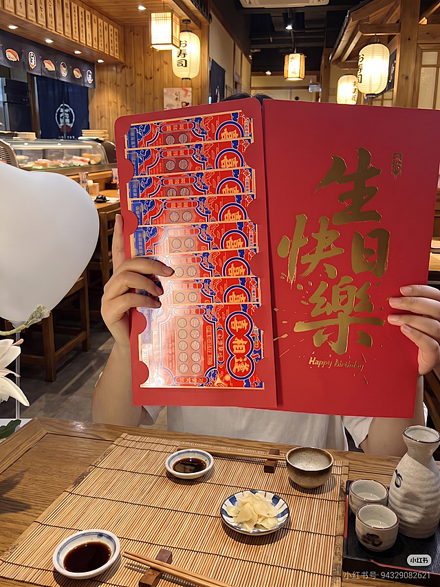 将前景的桌面改为符合日料店风格（如木质矮桌、竹席、酱油碟、小碗等传统日式餐具摆设），其余内容保持不变，不改变人物、红包、背景等元素的位置与外观