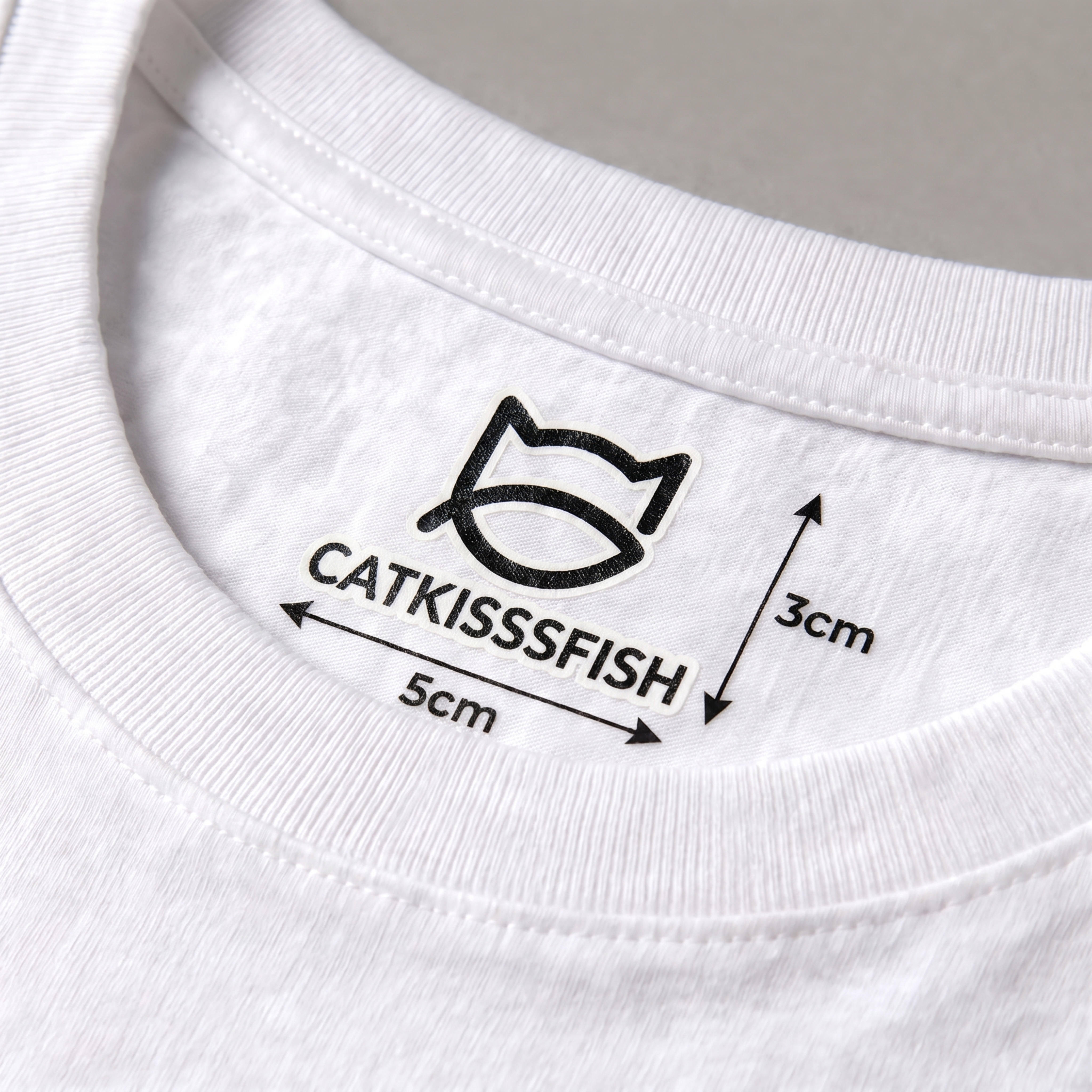放大并强调展示白色T恤内领口处的CATKISSSFISH烫画标… - 图片创意预览