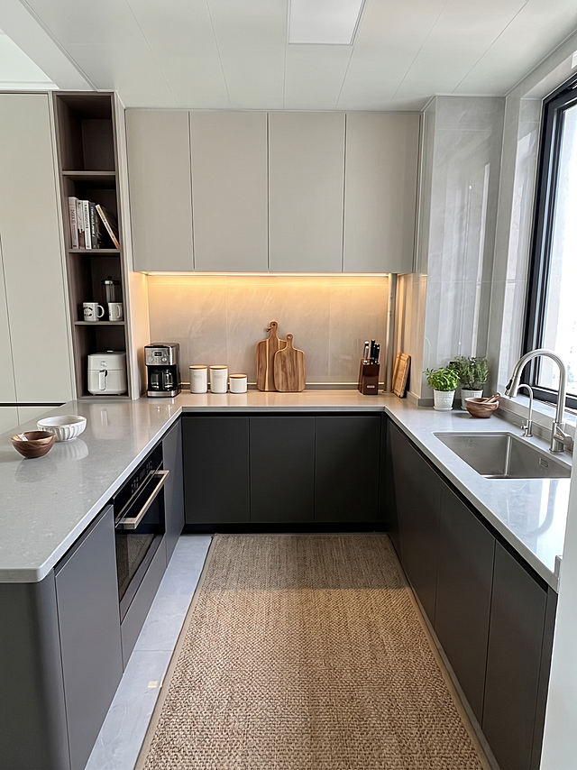 给这个未完工的厨房添加石质台面，搭配软装厨具和装饰品，营造温馨有氛围感的现代简约厨房，保持原有空间结构和橱柜配色不变