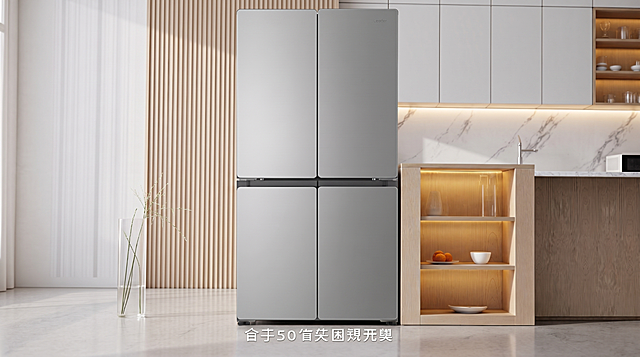 将图片1中原位置的白色单门冷柜原位替换为图片2(参考图)中的银灰色十字对开门四开门长方体冰箱。
用图2中冰箱的真实物理结构完全覆盖该区域，打破原图冷柜的轮廓束缚，保持原产品(图2)的真实比例，适配嵌入式空间，严禁挤压或变形。新产品需完美继承原图中冷柜的摆放角度、镜头高度与透视消失点关系，严格保持原图的透视效果，严禁改变透视关系，继承冷柜的底部接触点，严禁漂浮或位置偏移，使其与厨房背景空间完美融合。仅替换该物体，保持原图客厅厨房场景、浅色木格栅背景、右侧玻璃柜、左侧花瓶、地面以及底部文字所有其他环境布局和内容绝对不变。
适配原图环境光影，重置该区域光影，赋予自然接触阴影，完美消除新产品边缘白边，画面自然真实，严格锁定宽高比为 16:9，4K分辨率。