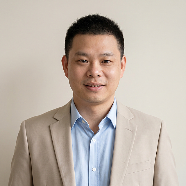 参考图中保留人物脸型、发型、年龄等特征生成通用职场大头像形象照，标准焦段50mm，f/4光圈，平视视角，镜头与人物视线齐平；人物占画面70%，人物居中，位于画面中心，为视觉聚焦点，入境范围仅头部及肩部，大头像特写；左右留少量背景空间；头部与画面顶部保留5%空间；头部发型完整，头肩比例协调，人物结构准确；浅蓝色高支精梳棉衬衫外搭浅米色西装外套，面料细腻哑光，着装正式干练，亲和可靠；身形匀称，姿态端正，身体挺拔。呈自然正面站姿，双手插兜，肢体放松且自信；发质微微柔顺，微微蓬松。简约浅米色纯色背景，呈现均匀柔和质感，背景光线均匀柔和，强化色彩对比的高级感，极简干净；画质超高分辨率、细节清晰，现代精致感风格；肤质精细化处理；眼神直视镜头，目光坚定且澄澈，表情自然，嘴角微微上扬；肤质自然细腻，肤色健康均匀，皮肤状态清爽干净，保留真实皮肤细节。正面柔光补光，4800K中性光，面部光比1:1.5。中近景写实摄影，对焦清晰，面部雾面柔光，轻透裸肌感，高清保留皮肤细节。分辨率4K，去除人物之外的所有元素，严格按照图片内容生成，画面比例1:1