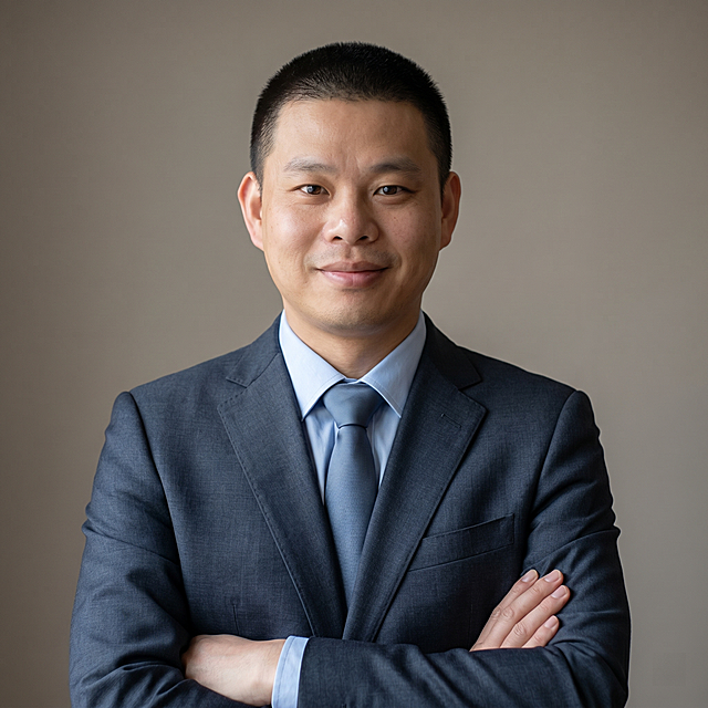 参考图中保留人物脸型、发型、年龄等特征生成通用职场大头像形象照，标准焦段50mm，f/4光圈，平视视角，镜头与人物视线齐平；人物占画面70%，人物居中，位于画面中心，为视觉聚焦点，入境范围仅头部及肩部，大头像特写；左右留少量背景空间；头部与画面顶部保留5%空间；头部发型完整，头肩比例协调，人物结构准确；身穿藏青色精纺羊毛混纺西装外套，平驳领设计，面料呈细腻微微哑光质感；内搭浅蓝色高支棉衬衫；搭配素色真丝领带；着装正式干练，严谨理性；身形匀称，姿态端正，身体挺拔。呈自然正面站姿，双手抱胸，肢体放松且自信；发质微微柔顺，微微蓬松。简约微微暖灰纯色背景，呈现均匀柔和质感，背景光线均匀柔和，强化色彩对比的高级感，极简干净；画质超高分辨率、细节清晰，现代精致感风格；肤质精细化处理；眼神直视镜头，目光坚定且澄澈，表情自然，嘴角微微上扬；肤质自然细腻，肤色健康均匀，皮肤状态清爽干净，保留真实皮肤细节。正面柔光补光，4800K中性光，面部光比1:1.5。中近景写实摄影，对焦清晰，面部雾面柔光，轻透裸肌感，高清保留皮肤细节。分辨率4K，去除人物之外的所有元素，严格按照图片内容生成，画面比例1:1