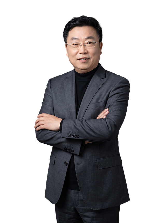 参考图中保留人物脸型、发型、年龄等特征生成职场形象照,标准焦段50mm,f/4光圈(f/2.8-f/4区间),平视视角(镜头与人物视线齐平);人物占画面70%,人物居中(居中构图),位于画面中心,为视觉聚焦点,入境范围头部及以下至臀部下方10cm(半身像);左右留少量背景空间;头部与画面顶部保留5%空间;头部发型完整,头肩比例协调,人物结构准确;发质微微柔顺，微微蓬松。身穿修身精纺羊毛混纺面料的深灰色西装外套(含5%桑蚕丝提升柔光质感),平驳领(商务感正式感),左胸袋无口袋巾(简化高级感),西装下摆自然垂度;内搭黑色中领紧身针织上衣,下装精纺羊毛混纺面料的深灰色高腰直筒西裤(面料同西装),搭配黑色哑光头层牛皮皮带(宽1.5cm),带扣为长方形拉丝黑色金属(1.8cm×2.5cm);着装正式干练;正式严谨专业稳重,身形匀称,姿态端正,身体挺拔。呈正面抱胸的自然站立姿态:左臂搭于右臂上方,肩颈自然松弛下沉,姿态自信从容;佩戴无框透明眼镜;简约冷调深灰色纯色背景(呈现均匀柔和质感),背景光线均匀柔和,强化色彩对比的高级感。极简干净;画质超高分辨率、细节清晰,现代精致感风格;肤质精细化处理;眼神直视镜头,目光坚定且澄澈,表情自然。嘴角上扬;肤质自然细腻,肤色健康均匀,皮肤状态清爽干净,保留真实皮肤细节｡正面柔光补光,4800K中性光,面部光比1:1.5｡中近景写实摄影,对焦清晰,面部雾面柔光,轻透裸肌感,高清保留皮肤细节｡分辨率4K,去除人物之外的所有元素。严格按照图片内容生成。画面比例3:4