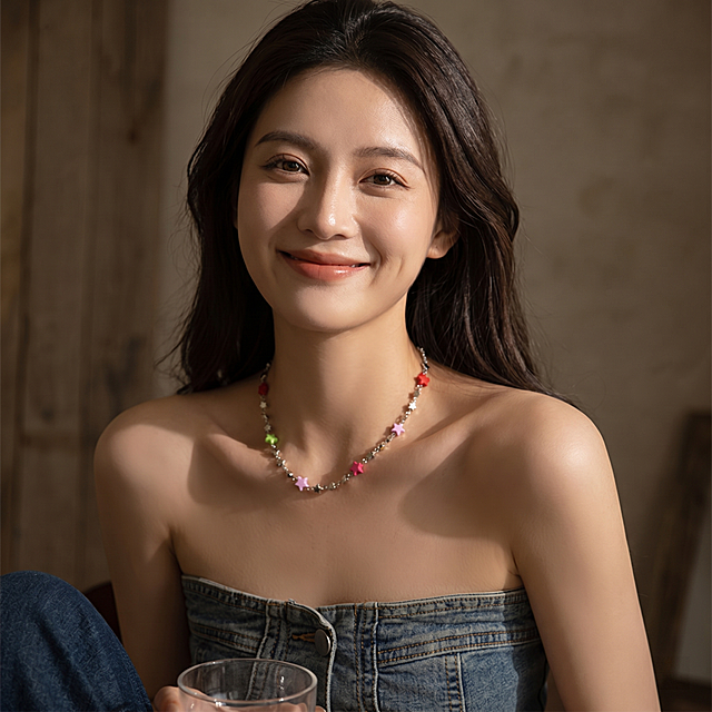 长相甜美，极强的表现力，微笑面对镜头，写实风格，远景深构图，柔焦美学，细腻肌理质感，极简风，突出人物立体轮廓与优雅气质，情绪叙事，整体氛围慵懒又随性，电影感，极强的光影对比，大师级摄影，极致细节，氛围感浓郁，空灵，时光凝固的感觉，色彩柔和褪色，带有忧郁的诗意和文学气息，保留并使用图片中的星星彩色项链