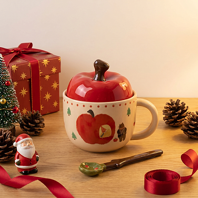 杯子严格参照上传产品图https://gdesign-dam-hz.dancf.com/36461033663087803/a3907e3daf2b408cb2481013a1feedb2.jpg，完整保留所有可见组件、部件、轮廓形状、结构、比例、材质质感、颜色与上传图完全一致，杜绝任何变形、色差、组件缺失、结构偏差。
室内桌面圣诞温馨场景，参考图https://1.jpg为温馨暖棕圣诞风格，相似度50%。
暖棕红圣诞色调，搭配木质桌面承载，和圣诞礼物、小圣诞树等圣诞元素组合摆放，柔和侧光（还原参考图暖光方向），产品受光面泛起暖棕红色、暗部映射深木色光晕，与环境物理融合。
产品居中特写，静态摆放，微侧偏转20°视角。
全量换款清单：①礼物盒：参考图红底雪花纹绿丝带方形礼盒 → 生成图红底星星纹红丝带方形礼盒；②圣诞树：参考图右侧大松枝 → 生成图左侧迷你装饰圣诞树；③小摆件：参考图右下角圣诞雪人小摆件 → 生成图左下角圣诞老人小摆件；④装饰：参考图右下角暖光串灯 + 前景雪花装饰 → 生成图周边散放松果装饰和红色丝带；⑤背景：参考图英文纸张背景 → 生成图米白色墙面背景；⑥桌面：参考图深胡桃木纹理桌面 → 生成图浅橡木纹理桌面。
温馨圣诞氛围，去除上传图中的促销文字、标签、水印、排版图层等非产品本体元素，仅保留产品logo与必要规格信息。
4K分辨率，严格锁定宽高比为 1:1。