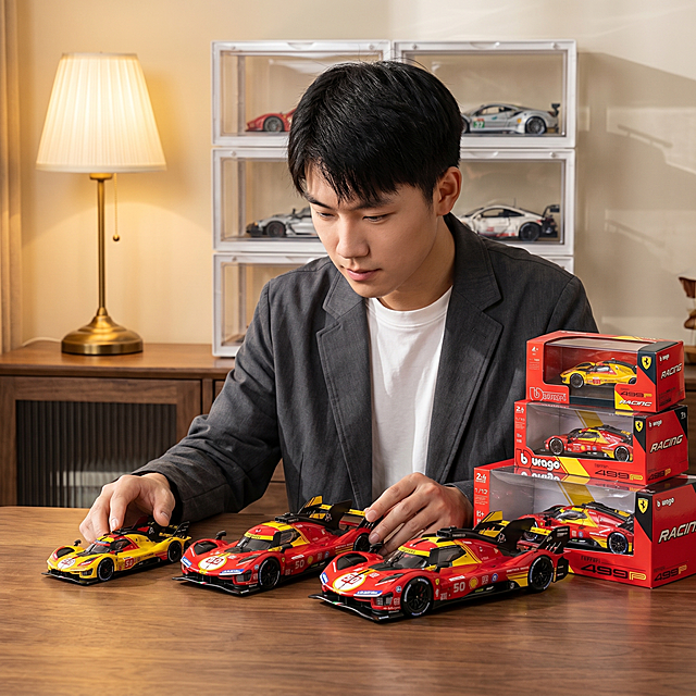车模玩具，严格参照上传产品图 https://gdesign-dam-hz.dancf.com/36496202238248035/417ca52a9dfc4490bbddbb575831f3ba.jpg ，完整保留所有可见组件、部件、轮廓形状、结构、比例、材质质感、颜色与上传图完全一致。
室内木质桌面陈列场景，参考图 https://gdesign-dam-hz.dancf.com/36496206938232990/bd1d9d85d6d442f59383693025cffe0d.png 进行仿图，80%相似度，暖棕自然色调。
中国年轻男性车模爱好者，俯身摆弄桌面车模，保留参考图人物性别、国籍、肤色、年龄段、姿态、与产品互动方式；还原参考图侧前方自然光方向，产品受光面泛起暖棕木色，暗部映射暖黄色光晕，与环境物理融合。产品位于画面偏下黄金位置，中景构图，微侧25°视角偏转。
全量换款清单：①人物：参考图黑色衬衫内搭白色T恤 → 生成深灰休闲西装外套内搭白色圆领T恤，黑色短发（保留原有姿态与互动）；②桌面：参考图浅原木 → 生成浅胡桃木纹理实木桌面；③陈列柜：参考图透明多层阶梯陈列柜 → 生成白色金属框架透明陈列柜；④背景灯光：参考图左侧金色底座落地灯 → 生成左侧黄铜底座米白灯罩落地台灯；⑤陈列车模：参考图银绿配色F1车模 → 生成红黄黑配色勒芒赛车模型
产品本体上的文字信息（logo / 型号 / 规格 / 参数 / 浮雕 / 刻度等）100% 保留不变；清除产品本体之外的装饰信息/卖点 / 水印 / 价格 / 排版角标 / 装饰边框等营销信息。
4K 分辨率，严格锁定宽高比为 1:1。