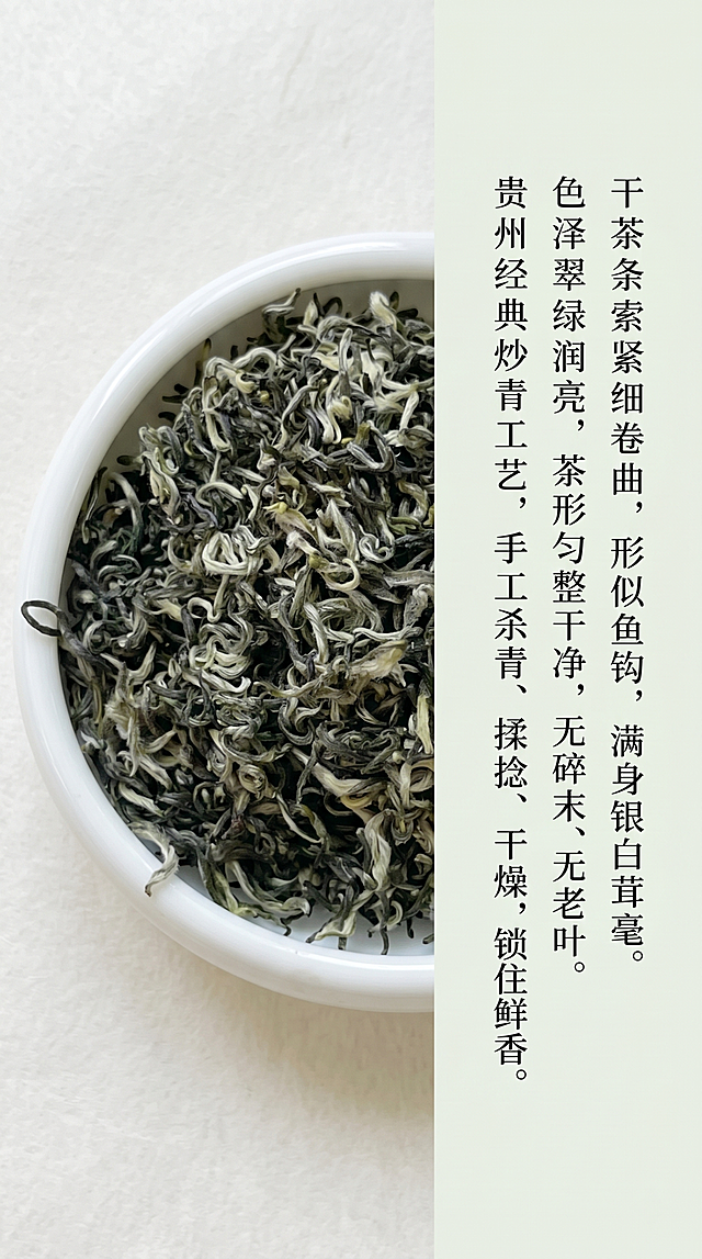 干茶细节鉴赏页，白色瓷盘平铺都匀毛尖干茶，自然光实拍，特写白毫和卷曲条索，莫兰迪浅绿搭配米白色调，低饱和度，风格极简高级国风，自然写实柔和哑光，左右图文排版，留白超过40%。左侧是干茶特写场景图，右侧是黑色深灰纤细文字介绍："干茶条索紧细卷曲，形似鱼钩，满身银白茸毫。色泽翠绿润亮，茶形匀整干净，无碎末、无老叶。贵州经典炒青工艺，手工杀青、揉捻、干燥，锁住鲜香。",文字排版干净，字体纤细高级，无花里胡哨装饰。