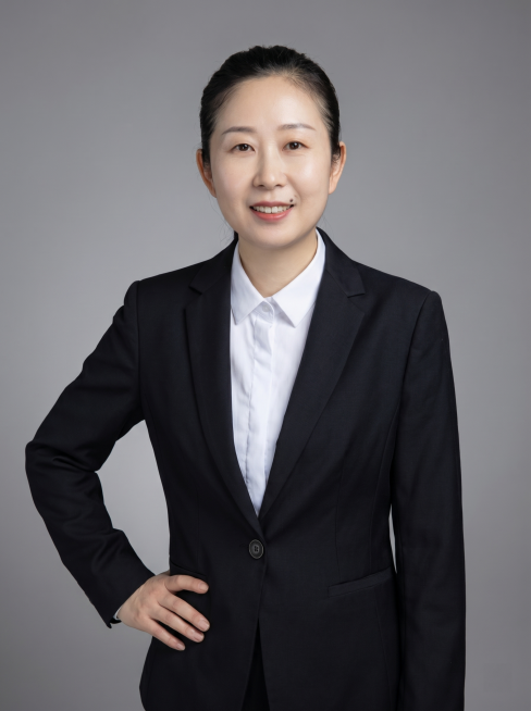 参考图中保留人物脸型、发型、年龄特征生成半身通用职场形象照，保留人物原有黑色西装搭配白色衬衫，保留配饰，人物呈站姿，单手叉腰，肢体放松自信。简约中性灰纯色背景，质感均匀柔和，背景光线均匀，极简干净，画预览效果