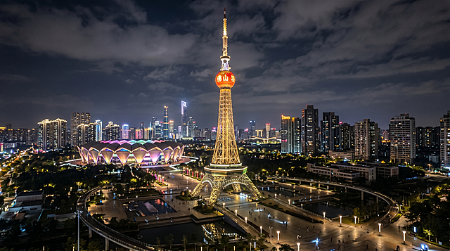 佛山城市高楼大厦夜景，以图片中的佛山电视塔为主体，画面中包含佛山世纪莲体育中心，整体为横版构图，参考佛山电视塔的钢结构和红色球体外观，保持夜景灯光效果
