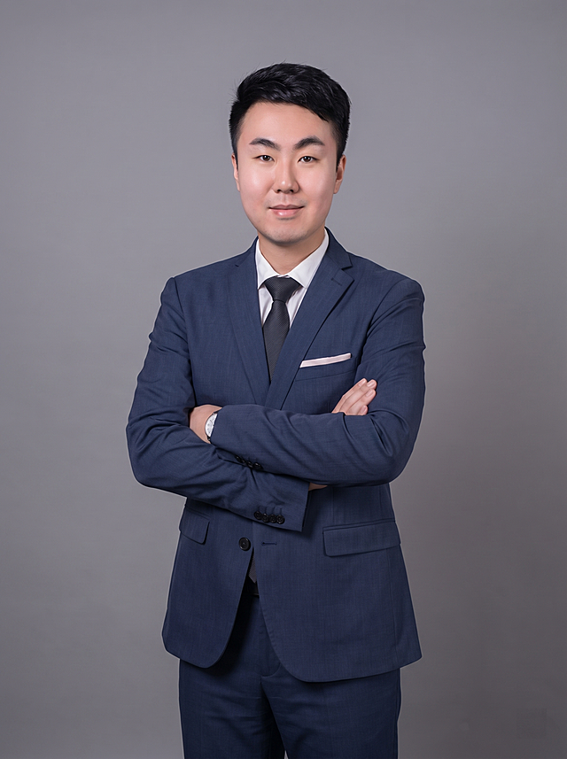 参考图中保留人物脸型、发型、年龄等特征生成职场全身形象照，标准焦段50mm,f/4光圈(f/2.8-f/4区间),平视视角(镜头与人物视线齐平);人物占画面中心，为视觉聚焦点，展现人物完整全身身形，全身照;头部与画面顶部保留合理空间;头部发型完整,头身比例协调,人物结构准确;身穿深蓝色精纺羊毛混纺西装外套(平驳领设计，面料细腻微微哑光质感);内搭白色高支精梳棉衬衫;下装深蓝色精纺羊毛混纺西裤;系黑色真丝领带，保留口袋巾;着装正式干练;专业稳重;身形匀称,姿态端正,身体挺拔。呈自然站姿，双手抱胸，肢体放松且自信;佩戴手表配饰，发质微微柔顺，微微蓬松。简约微微中度灰色纯色背景，呈现均匀柔和质感，背景光线均匀柔和，强化色彩对比的高级感，极简干净;画质超高分辨率、细节清晰,现代精致感风格;肤质精细化处理;眼神直视镜头,目光坚定且澄澈,表情自然。嘴角上扬;肤质自然细腻,肤色健康均匀,皮肤状态清爽干净,保留真实皮肤细节｡正面柔光补光,4800K中性光,面部光比1:1.5｡写实摄影,对焦清晰,面部雾面柔光,轻透裸肌感,高清保留皮肤细节;分辨率4K,去除人物之外的所有元素。严格按照图片内容生成。画面比例3:4