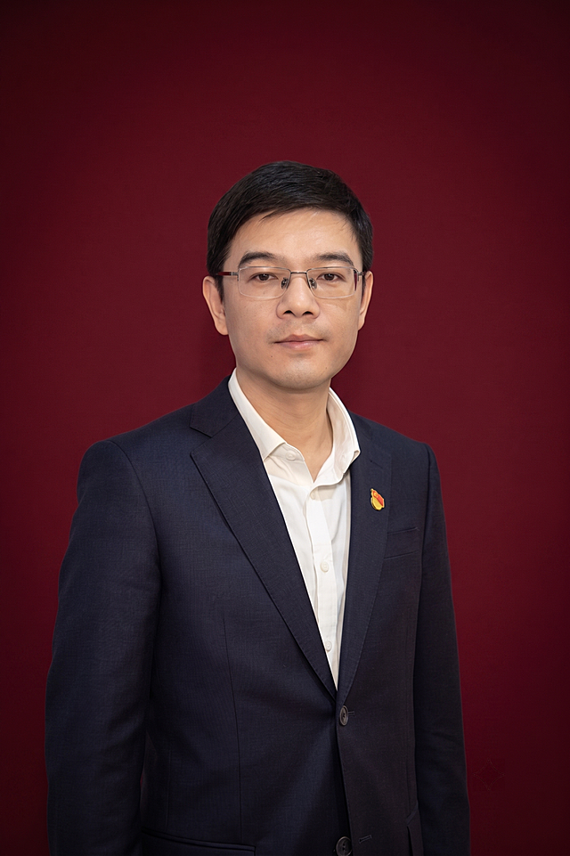 保留图中男士样貌与穿着，更换背景为简洁庄重的暗红色纯色背景，整体风格正式大方