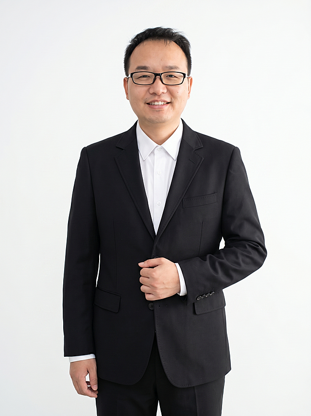 参考图中保留人物脸型、发型、年龄等特征生成职场形象照,标准焦段50mm,f/4光圈(f/2.8-f/4区间),平视视角(镜头与人物视线齐平);人物占画面70%,人物居中(居中构图),位于画面中心,为视觉聚焦点,入境范围头部及以下至臀部下方10cm(半身像);左右留少量背景空间;头部与画面顶部保留5%空间;头部发型完整,头肩比例协调,人物结构准确;发质微微柔顺，微微蓬松。身穿黑色精纺羊毛混纺西装外套,(平驳领设计,面料呈细腻微微哑光质感);内搭白色高支精梳棉衬衫;下装黑色精纺羊毛混纺西裤;着装正式干练;沉稳可靠、专业公正;身形匀称,姿态端正,身体挺拔。呈站姿，右手轻握西装前襟，肢体放松且自信;保留黑框眼镜配饰;简约纯白色纯色背景(呈现均匀柔和质感),背景光线均匀柔和,强化色彩对比的高级感。极简干净;画质超高分辨率、细节清晰,现代精致感风格;肤质精细化处理;眼神直视镜头,目光坚定且澄澈,表情自然。嘴角上扬;肤质自然细腻,肤色健康均匀,皮肤状态清爽干净,保留真实皮肤细节｡正面柔光补光,4800K中性光,面部光比1:1.5｡中近景写实摄影,对焦清晰,面部雾面柔光,轻透裸肌感,高清保留皮肤细节;分辨率4K,去除人物之外原红色背景和所有多余元素，只保留眼镜。严格按照图片内容生成。画面比例3:4