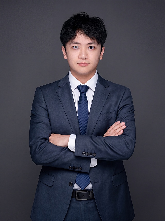 参考图中保留人物脸型、发型、年龄等特征生成职场形象照，身穿精纺羊毛混纺面料的深墨蓝色西装外套，含5%桑蚕丝提升柔光质感，平驳领增强商务感正式感，左胸袋无口袋巾保持简化高级感，西装下摆自然垂度；内搭长绒棉白色衬衫，温莎领，袖口贴合手腕1cm无堆叠；搭配精致且高级的深蓝色斜向微微渐隐光泽感极细条纹商务感领带，丝提花材质，低饱和柔光渐隐；下装精纺羊毛混纺面料的深墨蓝色高腰直筒西裤，面料同西装；搭配黑色哑光头层牛皮皮带，宽2.5cm，带扣为长方形拉丝黑色金属1.8cm×3cm。标准焦段50mm,F/4光圈，处于F/2.8-F/4区间，平视视角，镜头与人物视线齐平；人物占画面70%，人物居中，居中构图，位于画面中心为视觉聚焦点，入境范围头部及以下至臀部下方10cm，半身像构图，呈正面抱胸的自然站立姿态：左臂搭于右臂上方，肩颈自然松弛下沉，姿态自信从容，正式严谨专业稳重，身形匀称，姿态端正。背景为简约冷调深灰色纯色背景，呈现均匀柔和质感，极简干净背景，背景光线均匀柔和，强化色彩对比的高级感。画质超高分辨率、细节清晰，现代精致感风格；肤质精细化处理；眼神直视镜头，目光坚定且澄澈，表情自然。肤质自然细腻，肤色健康均匀，哑光肤质清爽干净，保留真实皮肤细节；杰作，最佳画质，超高细节，写实摄影，中近景人像，皮肤质感自然清晰，柔光，正面补光，画面干净清新，高清皮肤细节；面部光比1:1.5，4800K中性光，微微修饰脸型，肤质哑光细腻，面部雾面柔光，轻透裸肌感，真实毛孔纹理；分辨率4K，严格保留人物原有特征，画面比例3:4