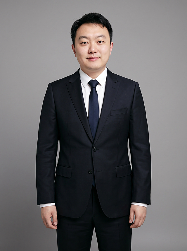 参考图中保留人物脸型、发型、年龄等特征生成职场形象照，标准焦段50mm，f/4光圈，平视视角，镜头与人物视线齐平；人物占画面合适比例，人物居中，居中构图，位于画面中心，为视觉聚焦点，全身照，展现人物完整身形；头部与画面顶部保留合适空间；头部发型完整，头身比例协调，人物结构准确；身穿深黑色精纺羊毛混纺西装外套，平驳领设计，面料呈细腻微微哑光质感；内搭白色高支精梳棉衬衫；下装深黑色精纺羊毛混纺西裤，搭配深蓝色真丝领带；着装正式干练；专业稳重；身形匀称，姿态端正，身体挺拔。呈自然站姿，双臂自然垂直身体两侧，肢体放松且自信；发质微微柔顺，微微蓬松，发梢微微修整，干练大气，主体锐利。简约微微中度灰色纯色背景，呈现均匀柔和质感，背景光线均匀柔和，强化色彩对比的高级感，极简干净；画质超高分辨率、细节清晰，现代精致感风格；肤质精细化处理；眼神直视镜头，目光坚定且澄澈，表情自然。嘴角上扬；肤质自然细腻，肤色健康均匀，皮肤状态清爽干净，保留真实皮肤细节。正面柔光补光，4800K中性光，面部光比1:1.5；分辨率4K，去除人物之外的所有元素。严格按照图片内容生成，画面比例3:4。