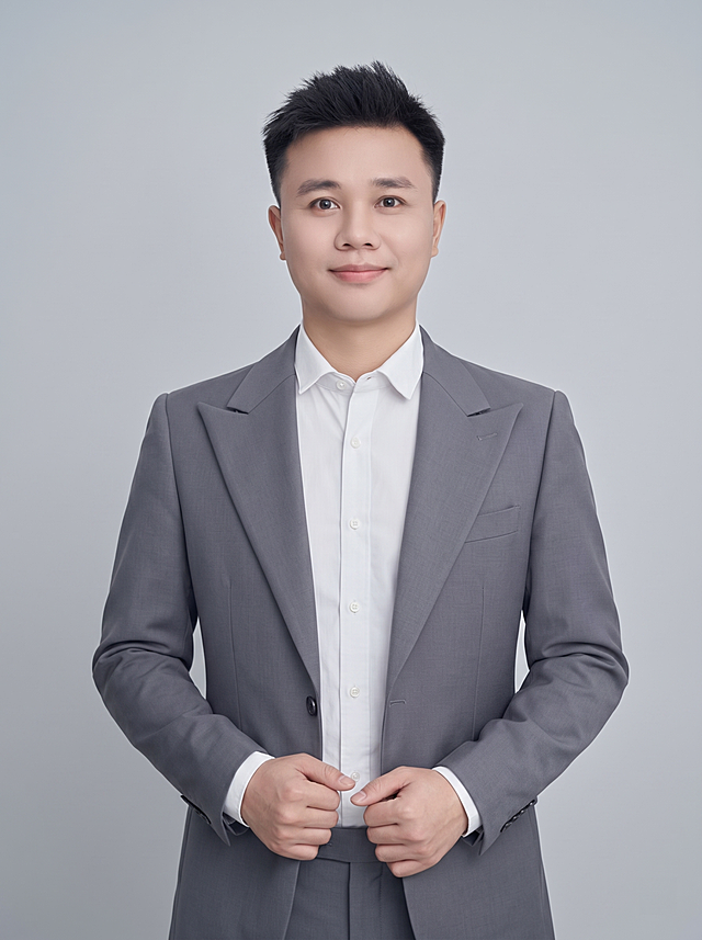 参考图中保留人物脸型、发型、年龄等特征生成职场半身形象照,标准焦段50mm,f/4光圈(f/2.8-f/4区间),平视视角(镜头与人物视线齐平);人物占画面70%,人物居中(居中构图),位于画面中心,为视觉聚焦点,入境范围头部及以下至臀部下方10cm(半身像);左右留少量背景空间;头部与画面顶部保留5%空间;头部发型完整,头肩比例协调,人物结构准确;发质微微柔顺，微微蓬松。身穿灰色精纺羊毛混纺西装外套,(平驳领设计,面料呈细腻微微哑光质感);内搭白色高支精梳棉衬衫;下装灰色精纺羊毛混纺西裤;着装正式干练;专业稳重;身形匀称,姿态端正,身体挺拔。呈自然站姿，双手交叠放在身前，肢体放松自然，不僵硬，表情自然略带微笑，亲和自信;简约微微中性灰色纯色背景(呈现均匀柔和质感),背景光线均匀柔和,强化色彩对比的高级感，极简干净;画质超高分辨率、细节清晰,现代精致感风格;肤质精细化处理;眼神直视镜头,目光坚定且澄澈;肤质自然细腻,肤色健康均匀,皮肤状态清爽干净,保留真实皮肤细节｡正面柔光补光,4800K中性光,面部光比1:1.5｡中近景写实摄影,对焦清晰,面部雾面柔光,轻透裸肌感,高清保留皮肤细节｡分辨率4K,去除人物之外的所有配饰，严格按照图片内容生成，画面比例3:4