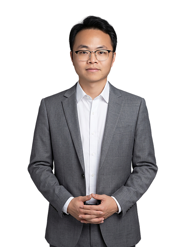 参考图中保留人物脸型、发型、年龄等特征生成职场半身形象照,标准焦段50mm,f/4光圈(f/2.8-f/4区间),平视视角(镜头与人物视线齐平);人物占画面70%,人物居中(居中构图),位于画面中心,为视觉聚焦点,入境范围头部及以下至臀部下方10cm(半身像);左右留少量背景空间;头部与画面顶部保留5%空间;头部发型完整,头肩比例协调,人物结构准确;发质微微柔顺，微微蓬松。身穿灰色精纺羊毛混纺西装外套,(平驳领设计,面料呈细腻微微哑光质感);内搭白色高支精梳棉衬衫;下装灰色精纺羊毛混纺西裤;着装正式干练;专业稳重;身形匀称,姿态端正,身体挺拔。呈自然站姿，双手交叠放在身前，肢体放松自然，不僵硬，表情自然亲和自信;保留现有黑框眼镜配饰；简约微微中性灰色纯色背景(呈现均匀柔和质感),背景光线均匀柔和,强化色彩对比的高级感，极简干净;画质超高分辨率、细节清晰,现代精致感风格;肤质精细化处理;眼神直视镜头,目光坚定且澄澈;肤质自然细腻,肤色健康均匀,皮肤状态清爽干净,保留真实皮肤细节｡正面柔光补光,4800K中性光,面部光比1:1.5｡中近景写实摄影,对焦清晰,面部雾面柔光,轻透裸肌感,高清保留皮肤细节｡分辨率4K，严格按照图片内容生成，画面比例3:4