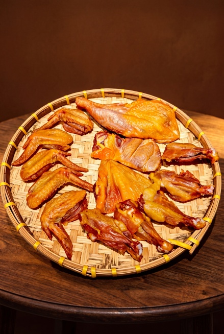 风干黄油鸡系列，严格参照上传产品图image1，完整保留所有可见组件、部件、轮廓形状、结构、比例、材质质感、颜色与产品本体上的文字信息，与上传图完全一致。参考image2背景和光线风格，暖棕深木色调。预览效果