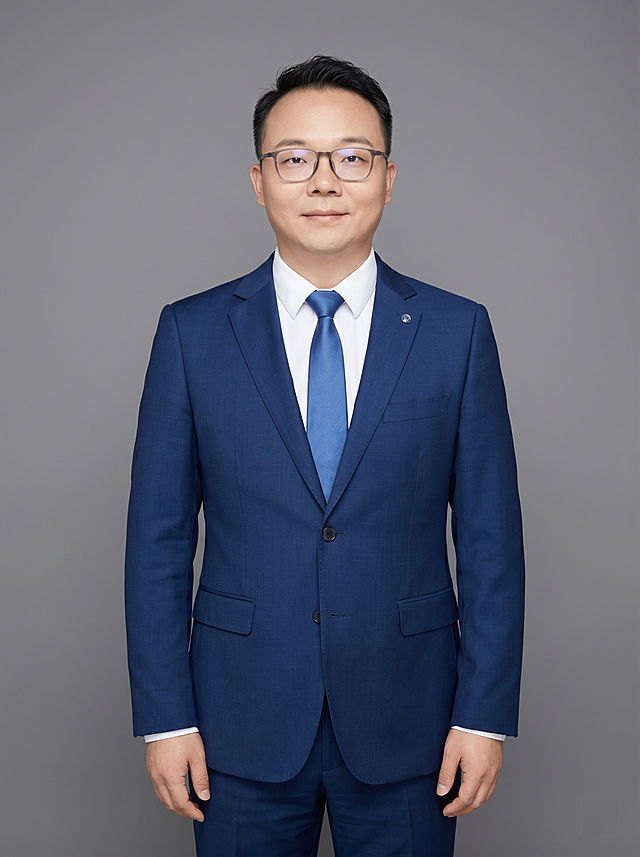 参考图中保留人物脸型、发型、年龄等特征生成职场形象照,标准焦段50mm,f/4光圈,平视视角(镜头与人物视线齐平);人物占画面中心,为视觉聚焦点,人物正面全身照,展现人物完整身形;头部与画面顶部保留合适空间;头身比例协调,人物结构准确;身穿深蓝色精纺羊毛混纺西装外套(平驳领设计,面料呈细腻微微哑光质感);内搭白色高支精梳棉衬衫;下装深蓝色精纺羊毛混纺西裤;系蓝色真丝领带;着装正式干练;专业稳重;身形匀称,姿态端正,身体挺拔。呈自然站姿，双手自然下垂，肢体放松且自信;佩戴眼镜与胸针，保留配饰特征;发质微微柔顺，微微蓬松。简约微微中度灰色纯色背景(呈现均匀柔和质感),背景光线均匀柔和,强化色彩对比的高级感。极简干净;画质超高分辨率、细节清晰,现代精致感风格;肤质精细化处理;眼神直视镜头,目光坚定且澄澈,表情自然。嘴角上扬;肤质自然细腻,肤色健康均匀,皮肤状态清爽干净,保留真实皮肤细节｡正面柔光补光,4800K中性光,面部光比1:1.5｡正面全身写实摄影,对焦清晰,面部雾面柔光,轻透裸肌感,高清保留皮肤细节;分辨率4K,去除人物之外的所有元素。严格按照图片内容生成,画面比例3:4