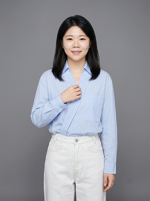 参考图中保留人物脸型、发型、年龄等特征生成教师职场形象照，标准焦段50mm，f/4光圈(f/2.8-f/4区间)，平视视角(镜头与人物视线齐平)；人物占画面70%，人物居中(居中构图)，位于画面中心，为视觉聚焦点，入境范围头部及以下至臀部下方10cm(半身像)；左右留少量背景空间；头部与画面顶部保留5%空间；头部发型完整，头肩比例协调，人物结构准确；身穿浅蓝色条纹高支精梳棉交领衬衫，白色阔腿牛仔裤；着装正式干练；知性亲和，沉稳儒雅；身形匀称，姿态端正，身体挺拔。呈自然站姿，右手轻握西装前襟，肢体放松且自信；发质微微柔顺，微微蓬松，保留耳环配饰，简约微微中度灰色纯色背景(呈现均匀柔和质感)，背景光线均匀柔和，强化色彩对比的高级感，极简干净；画质超高分辨率、细节清晰，现代精致感风格；肤质精细化处理；眼神直视镜头，目光坚定且澄澈，表情自然，嘴角上扬；清透自然裸妆(轻薄底妆+淡唇妆)妆感轻薄轻透裸肌感，通透感肤质，肤质自然细腻，肤色健康均匀，雾面柔光裸肌感，保留真实皮肤细节｡正面柔光补光，4800K中性光，面部光比1:1.5，色调明亮｡中近景写实摄影，对焦清晰，高清保留皮肤细节｡分辨率4K，去除人物之外的所有元素。严格按照图片内容生成，画面比例3:4。