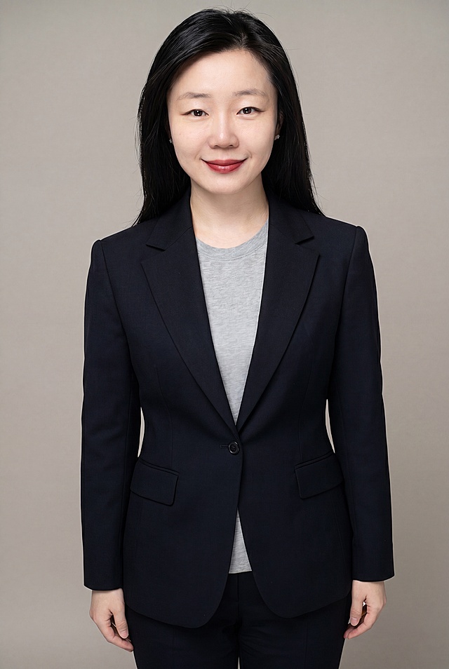 参考图中保留人物脸型、发型、年龄等特征生成职场形象照，标准焦段50mm，f/4光圈，平视视角，镜头与人物视线齐平，人物居中构图，位于画面中心，为视觉聚焦点，全身照，展现人物完整身形，全身舒展，头部与画面顶部留出合理空间，脚部与画面底部留出合理空间，头身比例协调，人物结构准确；身穿深黑色精纺羊毛混纺西装外套，平驳领设计，面料呈细腻微微哑光质感，内搭浅灰色高支精梳棉内搭，下装为深黑色精纺羊毛混纺西裤，着装正式干练，专业稳重，身形匀称，姿态端正，身体挺拔。呈自然站姿，肢体放松且自信，发梢微微修整，干练大气，主体锐利。简约微微暖调中性灰纯色背景，呈现均匀柔和质感，背景光线均匀柔和，强化色彩对比的高级感，极简干净；画质超高分辨率，细节清晰，现代精致感风格，肤质精细化处理，眼神直视镜头，目光坚定且澄澈，表情自然，嘴角上扬，肤质自然细腻，肤色健康均匀，哑光肤质清爽干净，保留真实皮肤细节，杰作，最佳画质，超高细节，写实摄影，全身人像，皮肤质感自然清晰，柔光，正面补光，画面干净清新，高清皮肤细节，面部光比1:1.5，4800K中性光，微微修饰脸型，肤质哑光细腻，面部雾面柔光，轻透裸肌感，真实毛孔纹理，去除所有配饰，分辨率4K，严格按照参考图人物特征生成，画面比例2:3