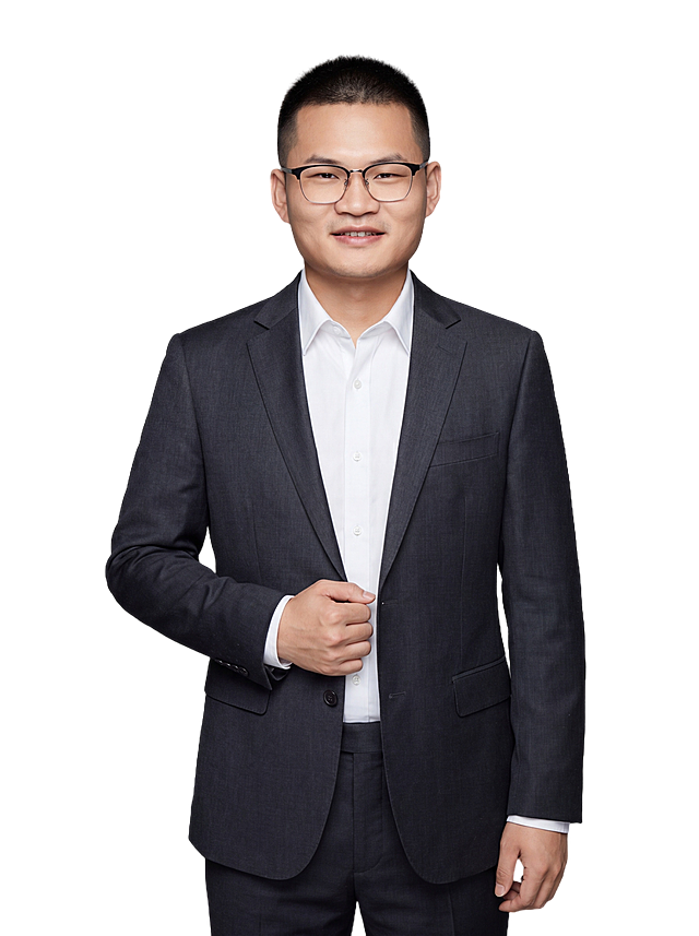 参考图中保留人物脸型、发型、年龄等特征生成职场形象照,标准焦段50mm,f/4光圈(f/2.8-f/4区间),平视视角(镜头与人物视线齐平);人物占画面70%,人物居中(居中构图),位于画面中心,为视觉聚焦点,入境范围头部及以下至臀部下方10cm(半身像);左右留少量背景空间;头部与画面顶部保留5%空间;头部发型完整,头肩比例协调,人物结构准确;发质微微柔顺，微微蓬松。身穿深炭灰色精纺羊毛混纺西装外套,(平驳领设计,面料呈细腻微微哑光质感);内搭白色高支精梳棉衬衫;下装深炭灰色精纺羊毛混纺西裤;着装正式干练;专业稳重;身形匀称,姿态端正,身体挺拔。呈自然站姿，右手轻握西装前襟，肢体放松且自信;佩戴黑框眼镜，保留配饰特征;简约微微中度灰色纯色背景(呈现均匀柔和质感),背景光线均匀柔和,强化色彩对比的高级感。极简干净;画质超高分辨率、细节清晰,现代精致感风格;肤质精细化处理;眼神直视镜头,目光坚定且澄澈,表情自然。嘴角上扬;肤质自然细腻,肤色健康均匀,皮肤状态清爽干净,保留真实皮肤细节｡正面柔光补光,4800K中性光,面部光比1:1.5｡中近景写实摄影,对焦清晰,面部雾面柔光,轻透裸肌感,高清保留皮肤细节｡分辨率4K,去除人物之外的所有元素。严格按照图片内容生成。画面比例3:4