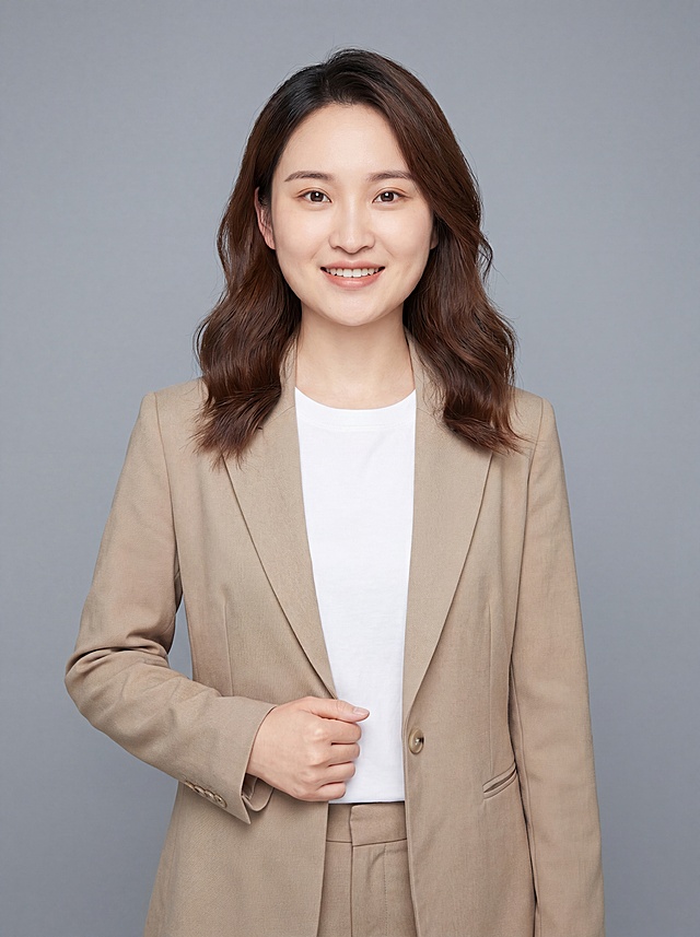 参考图片保留人物脸型、发型、年龄等特征生成美容顾问职场形象照,标准焦段50mm,f/4光圈(f/2.8-f/4区间),平视视角(镜头与人物视线齐平);人物占画面70%,人物居中(居中构图),位于画面中心,为视觉聚焦点,入境范围头部及以下至臀部下方10cm(半身像);左右留少量背景空间;头部与画面顶部保留5%空间;头部发型完整,头肩比例协调,人物结构准确;身穿米色精纺羊毛混纺西装外套,(平驳领设计,面料呈细腻微微哑光质感);内搭白色高支精梳棉圆领T恤;下装米色精纺羊毛混纺西裤;着装正式干练;亲和专业,温暖亲切;身形匀称,姿态端正,身体挺拔。呈站姿右手轻握西装前襟的自然姿态，肢体放松且自信;去除所有配饰；发质微微柔顺，微微蓬松。简约冷灰色纯色背景(呈现均匀柔和质感),背景光线均匀柔和,强化色彩对比的高级感，极简干净;画质超高分辨率、细节清晰,现代精致感风格;肤质精细化处理;眼神直视镜头,目光坚定且澄澈,表情自然。嘴角上扬;清透自然裸妆(轻薄底妆+淡唇妆)妆感轻薄轻透裸肌感,通透感肤质,肤质自然细腻,肤色健康均匀,雾面柔光裸肌感,保留真实皮肤细节｡正面柔光补光,4800K中性光,面部光比1:1.5,色调明亮｡中近景写实摄影,对焦清晰,高清保留皮肤细节;分辨率4K,去除人物之外的所有元素。严格按照图片内容生成，画面比例3:4