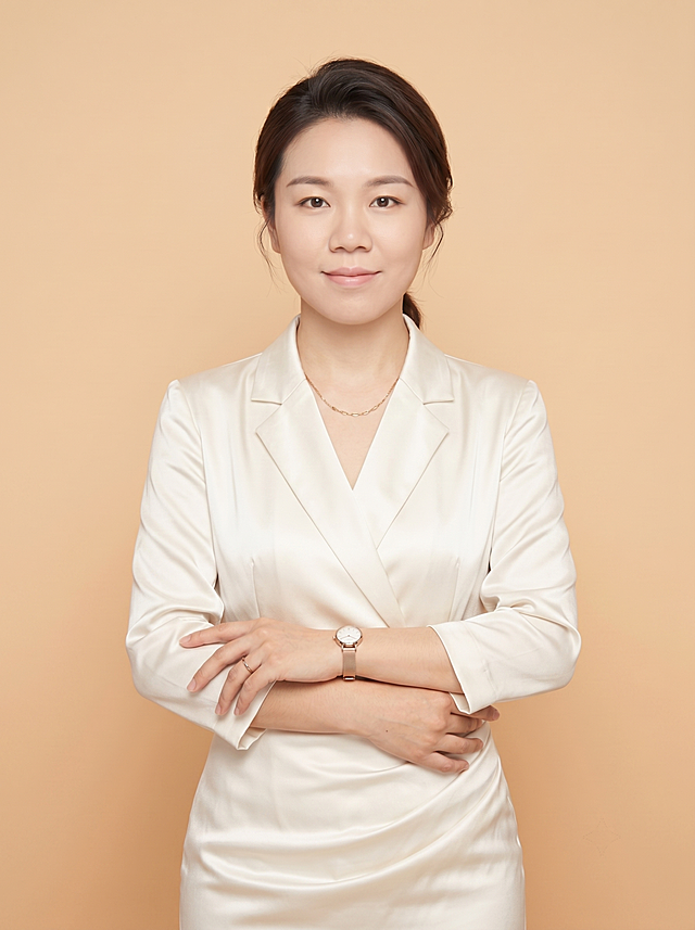 保留原图片人物脸型、发型、年龄、姿势、配饰、背景不变，只将衣服颜色更换为白色缎面职业西装裙装，保持整体光影和质感一致
